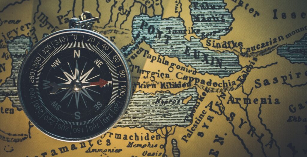 Top view of a compass on a map (Unsplash)