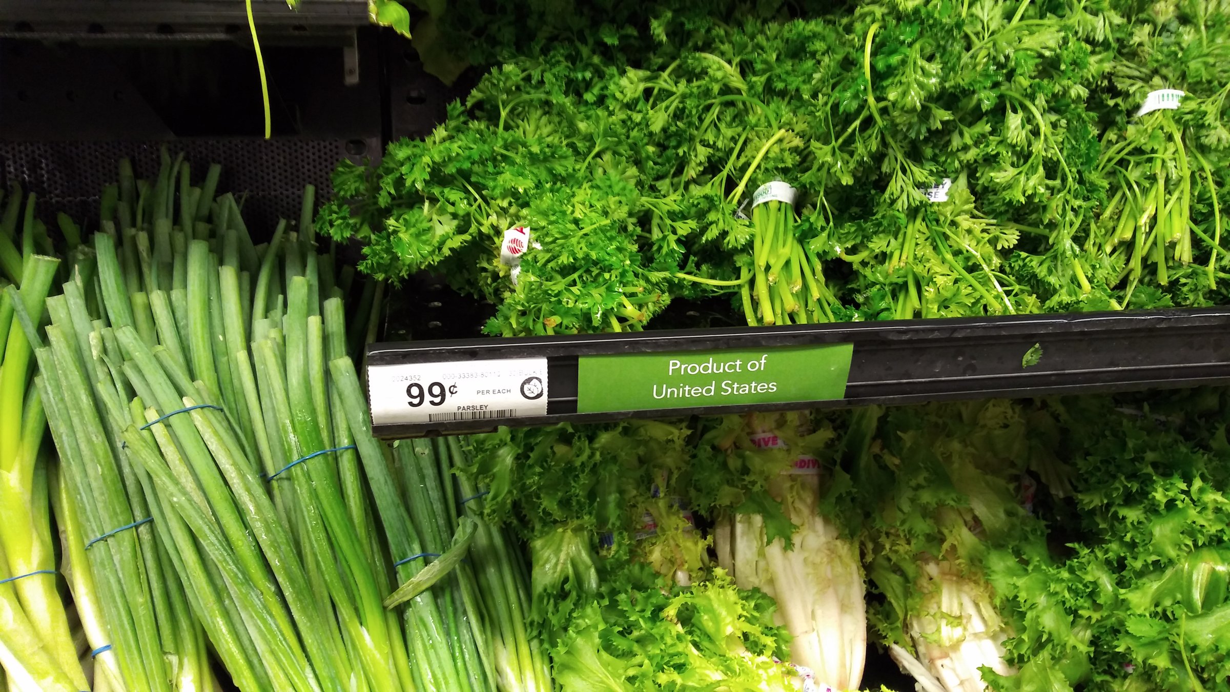 US supermarket produce shelf with 99¢ parsley price tag and Product of United States label